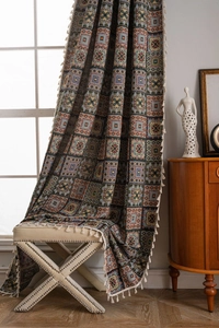 Close-up of geometric jacquard knit fabric with boho fringe and textured pattern