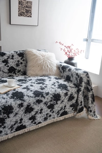 Détail du jeté de canapé jacquard avec bords à franges et motifs floraux rétro