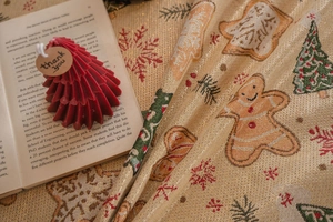 Detail of Christmas jacquard tablecloth with gingerbread man and festive tree patterns