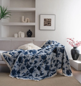 Detail of blue and white jacquard sofa throw blanket with stylish tassel fringe edges