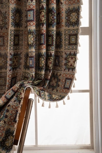 Detail of woven jacquard curtain featuring bohemian geometric patterns and cream fringe