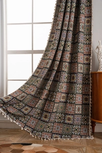 Detailed texture of geometric jacquard fabric curtain with decorative white tassels