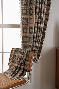 Detail of bohemian geometric jacquard fabric curtain featuring short cream fringes