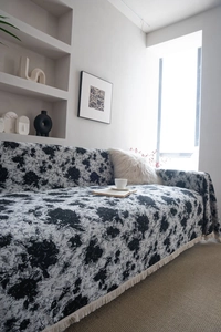 Détail de jeté de canapé jacquard fleuri noir et blanc avec d'élégantes franges crème