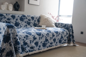 Detail of blue floral jacquard sofa throw blanket with thick chenille and fringe edges