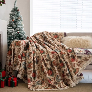 Christmas woven sofa throw with festive pinecones and red berries on a cream background