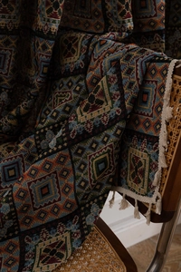 Detail of geometric jacquard fabric with bohemian diamond patterns and white tassels