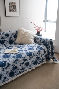 Close-up of blue and white jacquard sofa cover with thick woven texture and fringed edges