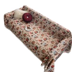 Christmas themed sofa cover with festive bell patterns and white tassel edges