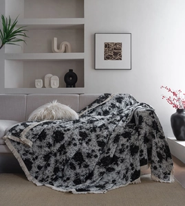 Vue détaillée du jeté de canapé en jacquard noir et blanc avec des franges décoratives