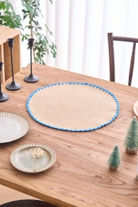 Close-up of a natural burlap round placemat featuring elegant blue crochet lace edging