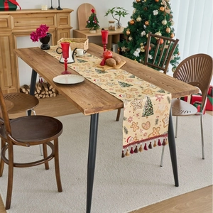 Weihnachts-Tischläufer mit Lebkuchen-Jacquard und Quasten auf einem Holzesstisch