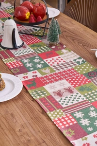 Close-up of jacquard Christmas table runner featuring reindeer, snowflakes and plaid patterns