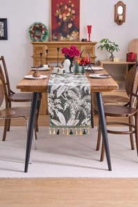 Dettaglio del runner da tavolo jacquard con foglie di palma e nappe decorative