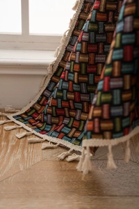 Vue détaillée du textile jacquard géométrique coloré avec des finitions à franges