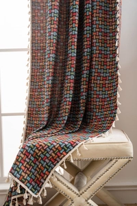 Détail de tissu jacquard géométrique bohème coloré avec bord à franges et glands
