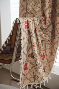 Detailed view of Christmas jacquard tapestry with red bows and elegant white tassels