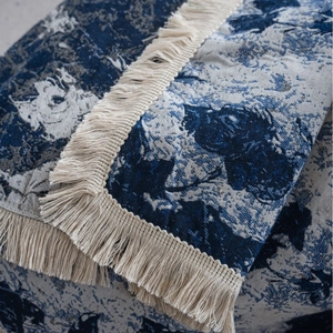 Blue and white jacquard sofa cover throw with thick floral pattern and tassel edges