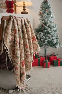 Close-up of Christmas throw blanket with jacquard bows and holly leaves on a chair