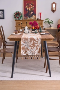 Dettaglio del runner da tavola jacquard con motivi a foglie e frange eleganti