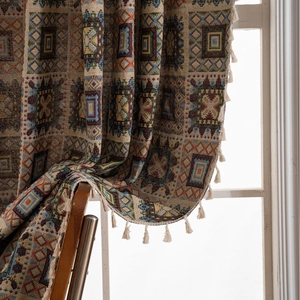Retro geometric jacquard curtain fabric with tassel fringe edge hanging on a chair
