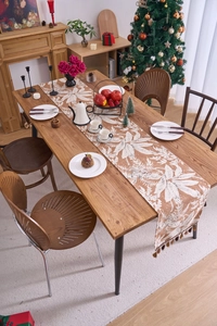 Dettaglio del runner da tavola terracotta con stampa floreale bianca e nappe