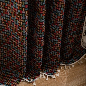 Rideau ethnique coloré à motif de tissage de panier avec des franges blanches sur parquet