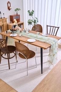 Detail of light green lace table runner with colorful floral embroidery and soft mesh fabric