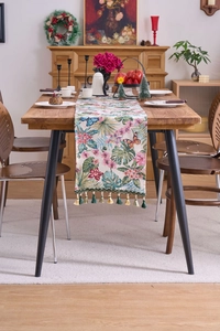 Close-up of floral jacquard table runner featuring butterfly patterns and elegant green tassels