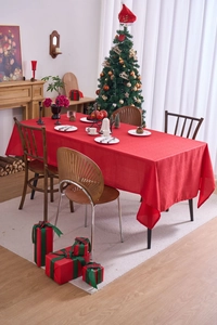 Detail of red rectangular Christmas tablecloth with textured fabric in a festive home setting