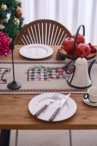 Detailed close-up of Jacquard Christmas table runner with snowman and plaid Joy letters