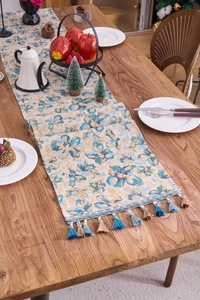 Macro detail of Nordic blue floral jacquard table runner with thick woven texture and tassels