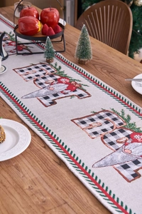 Close-up of jacquard Christmas table runner with JOY text and festive gnome design