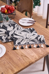 Dettaglio del runner da tavolo con foglie di palma bianco e nero e nappe decorative