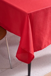 Close-up of bright red cotton linen festive tablecloth with fine woven texture and neat stitching