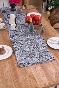 Detailed view of paisley table runner on wooden desk with Christmas decor and tea set