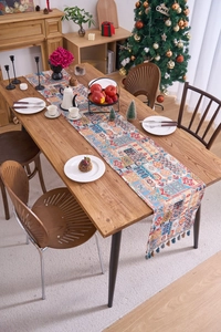Dettaglio del runner da tavola jacquard nordico con motivi geometrici e nappe