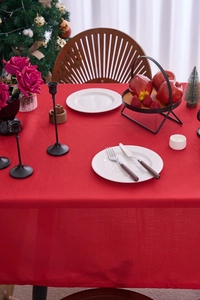 Close-up of red festive tablecloth with textured weave for Christmas dinner setting