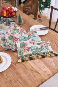 Macro detail of jacquard table runner with tropical monstera leaves and fringe edges