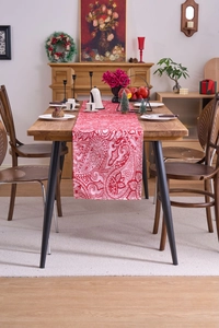 Close-up of red and white paisley jacquard table runner on a wooden dining table
