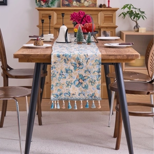 Nordic blue jacquard table runner with fringe tassel on a wooden dining table
