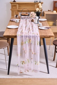 Close-up of pink lace table runner featuring colorful flower embroidery and mesh texture