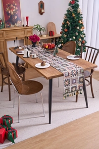 Detail of bohemian geometric jacquard table runner with colorful tassels in Christmas setting