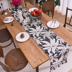Runner da tavola moderno bianco e nero con foglie tropicali e nappine decorative