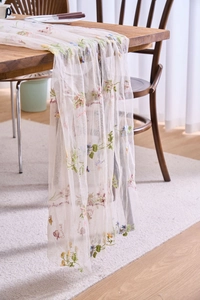 Detailed close-up of French vintage lace table runner with floral embroidery and cursive text