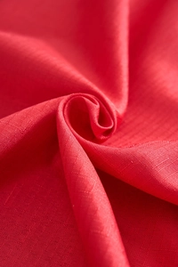 Macro shot of red festive tablecloth showing natural linen texture and woven detail