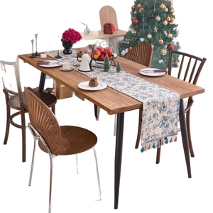 Blue Nordic floral jacquard table runner with decorative tassels on a wooden table
