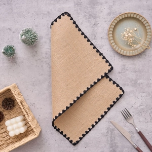 Gros plan sur un set de table en jute rectangulaire avec bordure en crochet noir