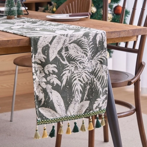 Runner da tavola con foglie di palma tropicale e nappe su tavolo in legno