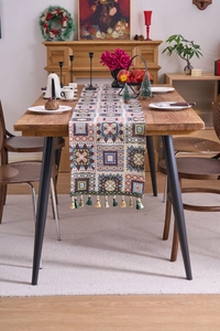 Detail of bohemian jacquard table runner with geometric patterns and fringe tassels